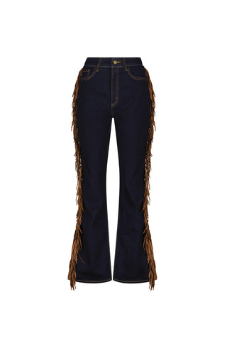 The Ryder Fringe Jean - Indigo features high-rise dark blue denim with flared legs and brown suede fringe on the outer sides, shown against a plain white background.
