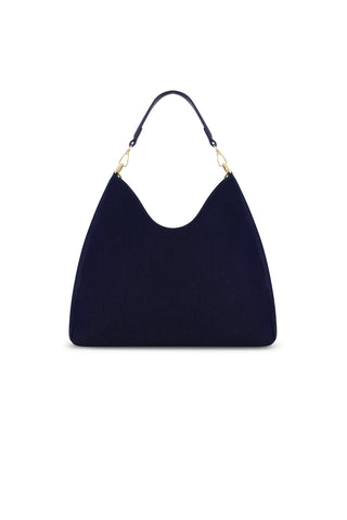 The Tribeca Chain Denim Bag in indigo features a hobo style with a curved top, single short handle, and gold-tone hardware, shown against a white background.