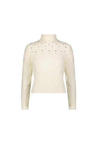 The Cara Crystal Sweater - Pearl is a cream-colored, long-sleeve knit with a ribbed mock neck, diamond-patterned texture, and pearl-like embellishments—ideal for winter layering.
