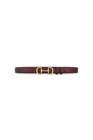 The Bettie Belt - Merlot is a slim burgundy pebbled faux leather belt with a striking gold double-ring horsebit buckle, shown on a white background.