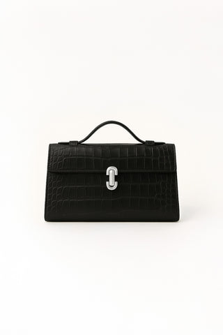The Danica Croco Clutch - Black features faux-crocodile leather, a top handle, flap closure, and a silver clasp, shown against a plain white background.