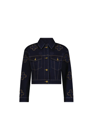The Kaia Studded Jacket - Indigo is a dark blue denim jacket featuring gold buttons, front pockets, and decorative gold studs in clover and geometric patterns with subtle floral stitching on the chest, shoulders, sleeves, and cuffs.