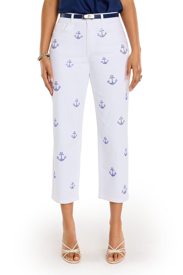 Wearing the Kelsey Cropped Jean - Crystal Anchors, styled with a navy top, white sandals, silver bracelet, ring, and white belt. Photo shows shoulders down against a white background.