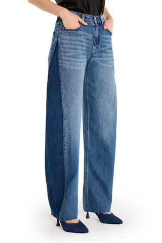 Model wears Selena Barrel Jean - Medium Blue, featuring a high-rise barrel fit with dual-tone denim and dark blue side panels, styled with pointed-toe denim heels. Top half not visible.