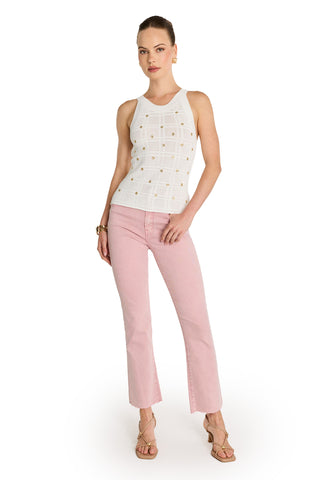 A woman poses with one hand on her hip against a white background, wearing the Mary Embellished Top - Pearl, light pink cropped jeans, beige strappy sandals, and gold hoop earrings.