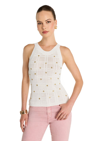 A woman poses against a white background wearing the Mary Embellished Top - Pearl and light pink jeans. Her hair is pulled back, with gold earrings and a bracelet—showcasing a chic boutique-inspired ensemble.