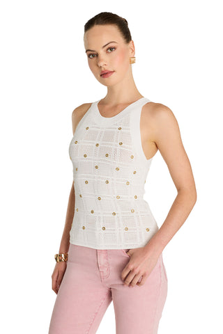 A woman wears the Mary Embellished Top - Pearl with gold accents and light pink jeans, standing against a white background and looking at the camera with one hand by her side.