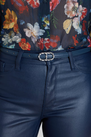 The Mabel Belt in oxford navy worn at the waist, showing the silver oval buckle