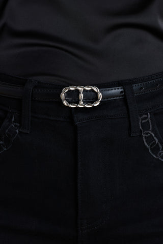 The Mabel Belt in black and silver worn at the waist, showing the interlocking oval buckle