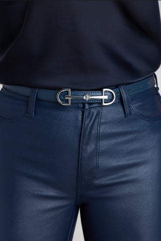 The Heritage Belt in oxford navy worn at the waist, showing the slim strap and silver horsebit buckle
