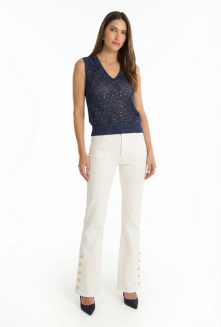 A woman in white pants and the navy Addison Sequin Crochet Top creates a fresh and stylish look.