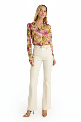 A woman poses against a white background wearing the Ana Chiffon Blouse in a pink, yellow, and brown floral print, paired with ivory high-waisted belted pants and tan high-heeled shoes.