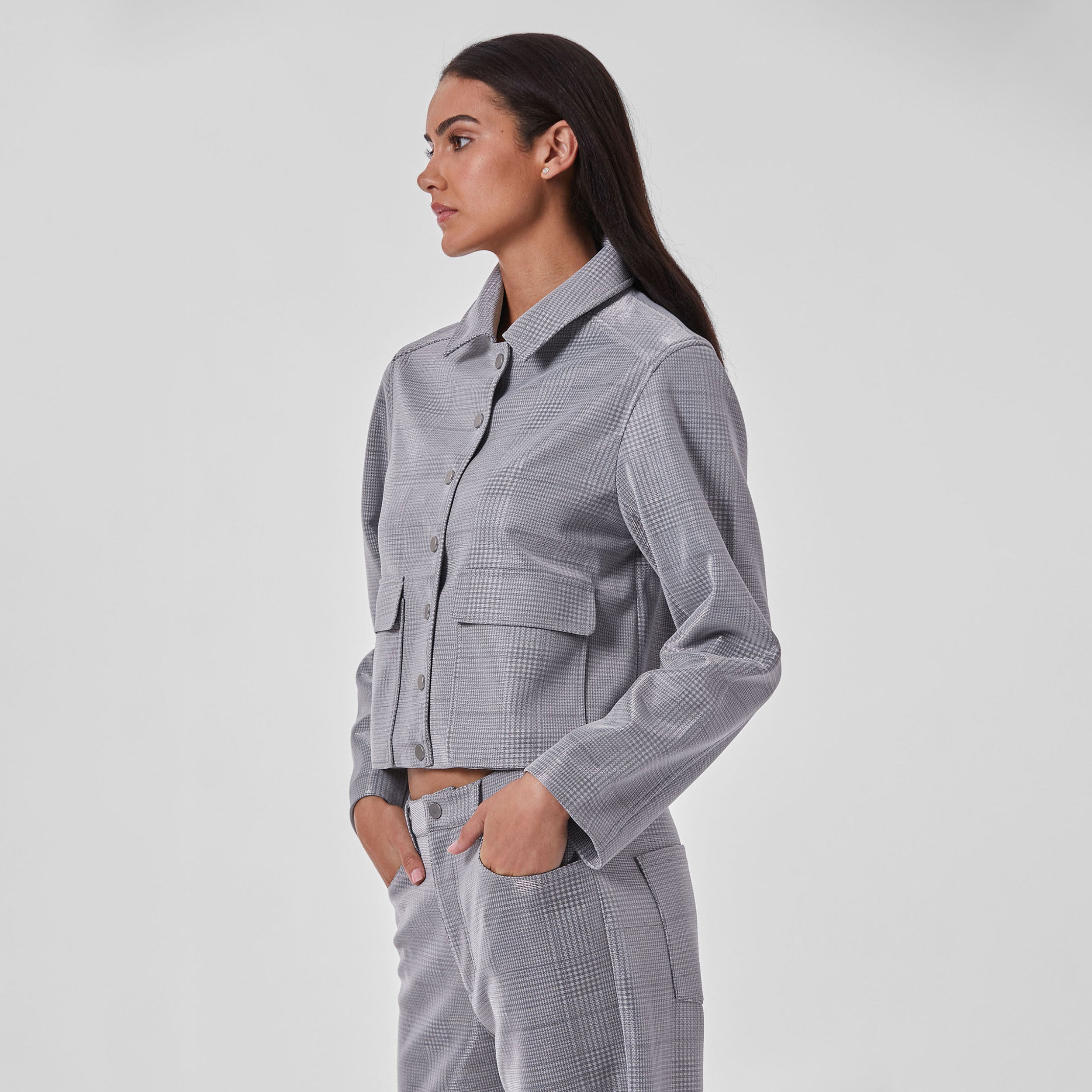 Side profile of woman wearing silver plaid patterned cropped jacket and matching pants.