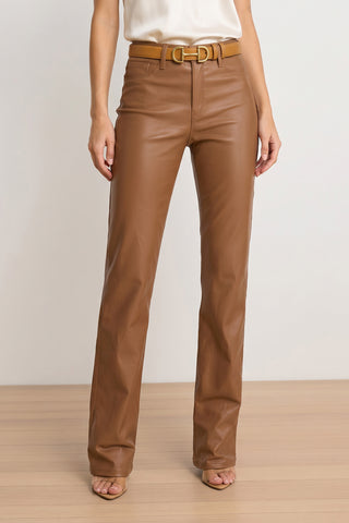 A woman wears Aria Coated Flare Jean - Mocha high-rise stretch denim pants with a matching belt and tan heeled sandals, standing on a wooden floor against a plain white background. Her upper body is partially out of frame.