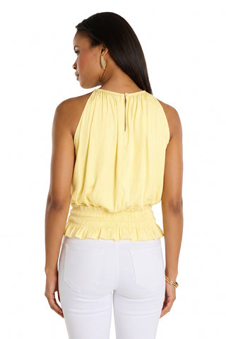 A woman is seen from the back, looking left, wearing the Betsy Halter Top - Sunshine Yellow with white pants. Her long dark hair and gold earrings add to this chic summer look featuring a sleeveless design and gathered waist.