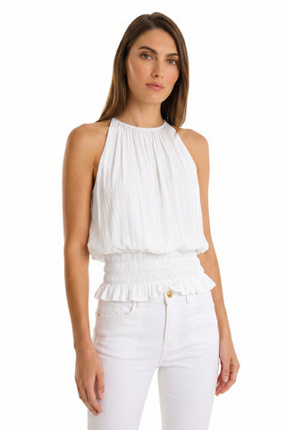 A woman with straight brown hair wears the Betsy Halter Top in white and matching white pants, standing against a plain white background and facing the camera with a neutral expression.