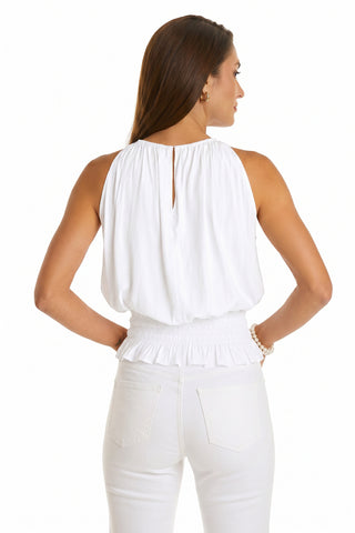 A woman with long brown hair is seen from the back wearing the Betsy Halter Top - White with high-waisted white pants, posing against a plain white background.