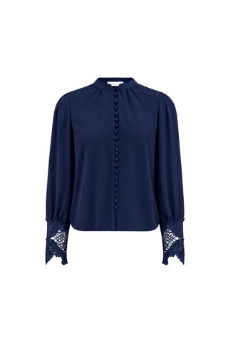 The Blake Lace Sleeve Blouse in navy features a high collar, button-down front, and delicate lace detailing on the sleeves and cuffs.