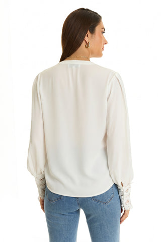 A woman with long brown hair wears the Blake Lace Sleeve Blouse in white, paired with blue jeans and gold hoop earrings, shown from the back against a plain white background.