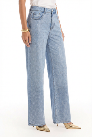 Wearing the Brynn Crystal Jean - Medium Blue, featuring stylish high-rise wide-leg jeans adorned with sparkling crystal accents.