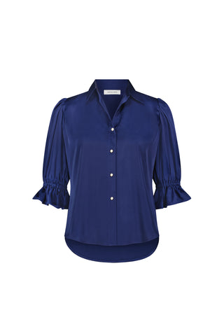 The Cindy Ruffle Sleeve Blouse - Navy is a feminine top with short puffed ruffle sleeves, gold front buttons, a classic collar, and a slightly longer curved hem at the back.