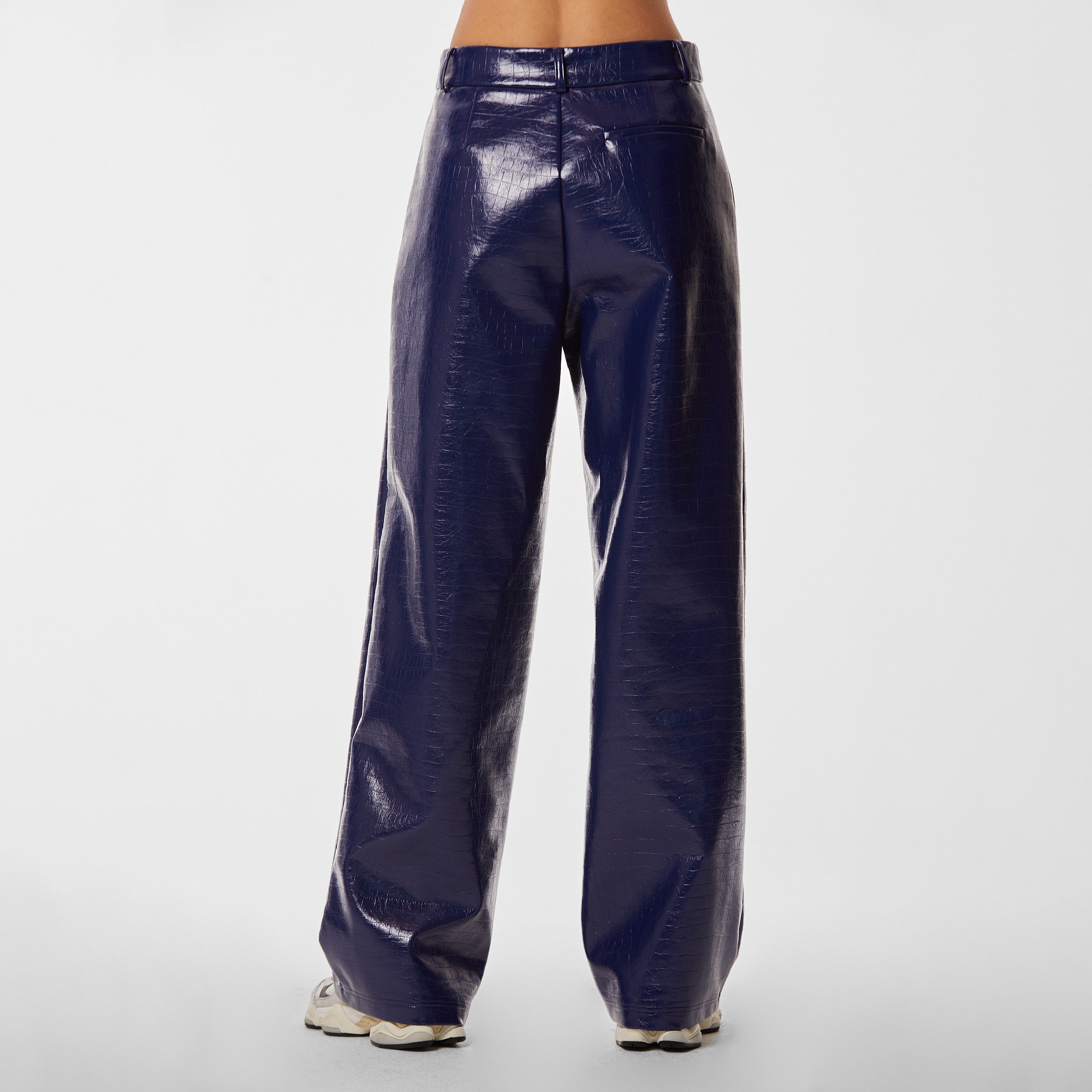 Rear view of woman wearing navy blue faux leather croco pattern embossed wide leg pant.