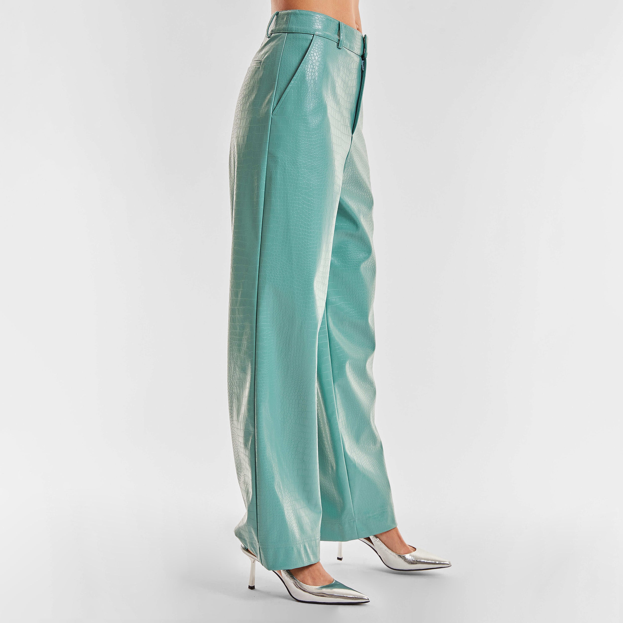 Side view of woman wearing sage colored faux leather croco pattern embossed wide leg pant.