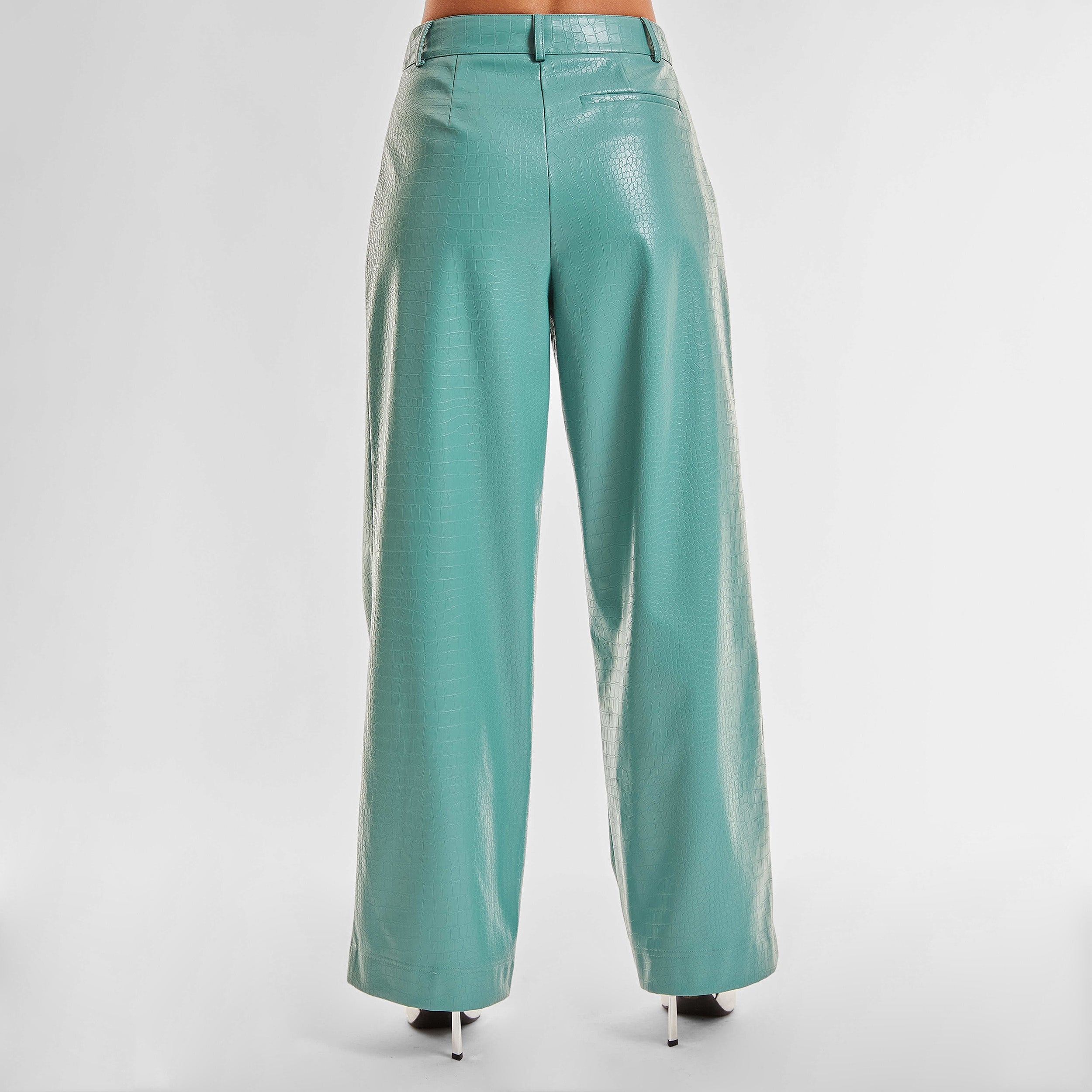 Rear view of woman wearing sage colored faux leather croco pattern embossed wide leg pant.