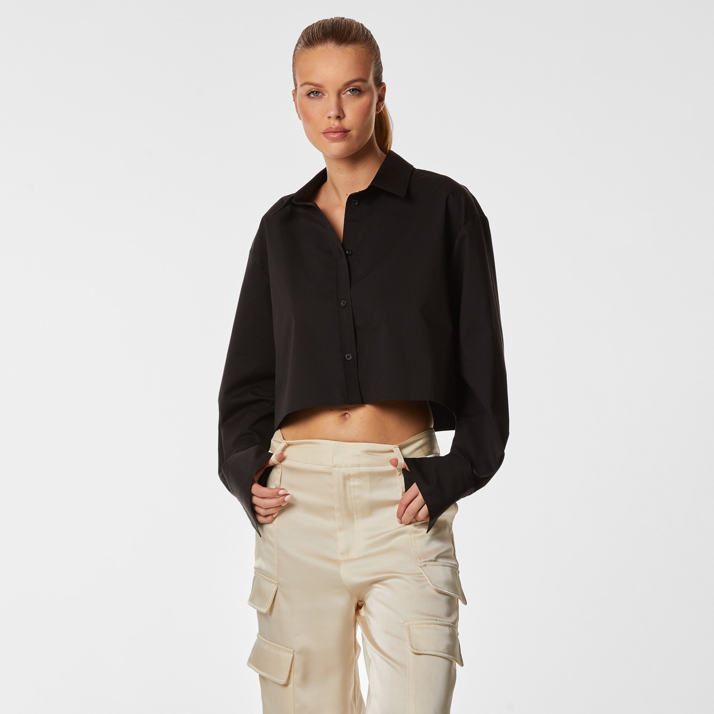 Front view of woman wearing a black cropped button down shirt