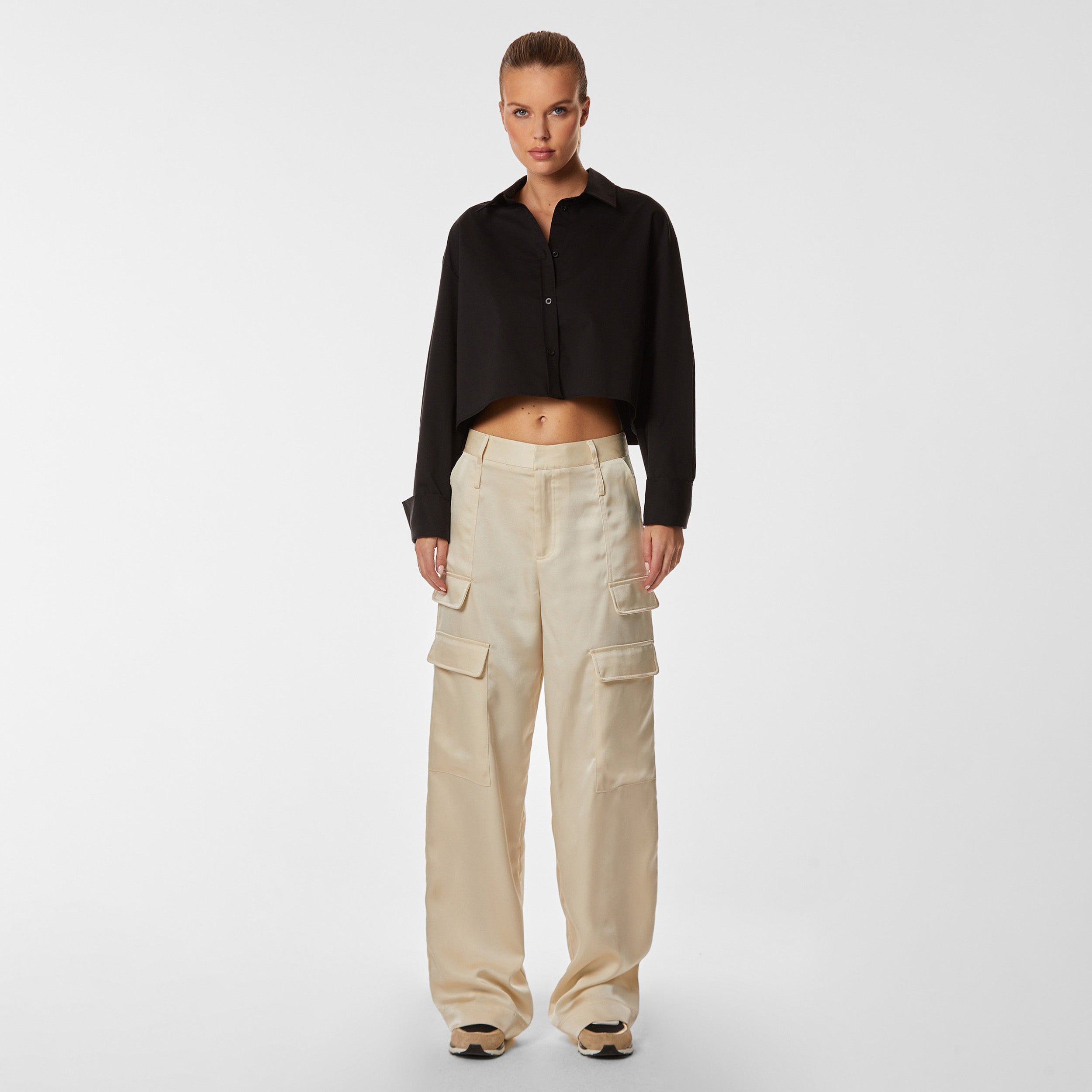 Front view of woman wearing a black cropped button down shirt and pearl wide leg cargo pant.