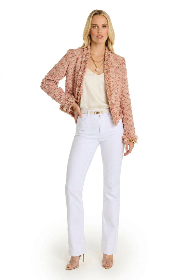A woman poses in front of a white background wearing the Florence Tweed Jacket - Rose Multi, styled with a white top, white pants, nude heels, layered necklaces, and a belt—a chic choice for summer layering.