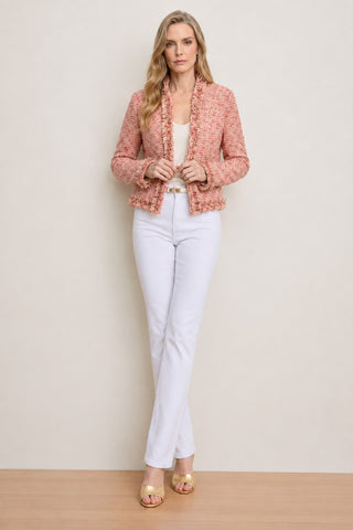 A woman with wavy blonde hair poses confidently against a neutral backdrop in the Florence Tweed Jacket - Rose Multi, styled over a white top and pants, with gold open-toe heels adding an effortless touch to her look.