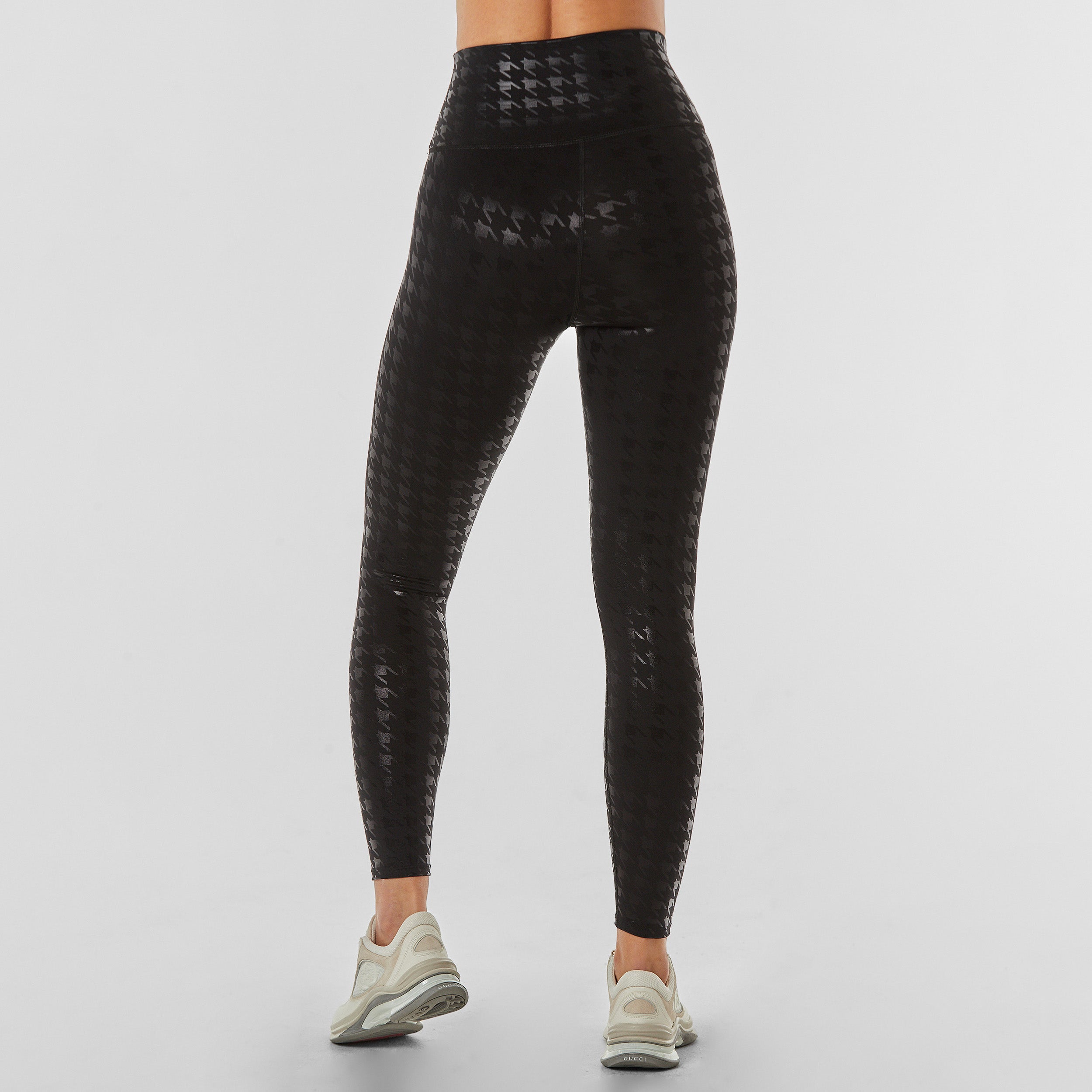 Rear view of woman wearing black on black glossy houndstooth patterned legging