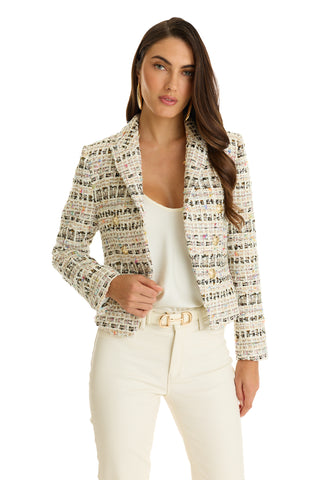 A woman with long brown hair wears the Gabrielle Double Breasted Tweed Blazer - Ecru Multi over a white top and cream pants, standing against a plain white background and looking confidently at the camera.