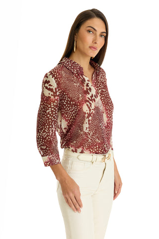 A woman posing for a picture in the Sara Chiffon Blouse - Garnet Crush, featuring a chic design and stylish high-low hem.