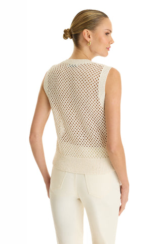 A woman with her hair in a bun is shown from the back against a white background, wearing the Addison Sequin Crochet Top in Pearl, a sleeveless open-knit sweater, styled with cream pants.