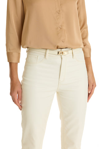 A person wears high-waisted white pants with the Nicola Belt - Pearl and a beige button-up blouse, standing with one hand by their side. The image is cropped from the shoulders down.