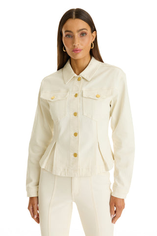 A woman with long straight brown hair wears the Bethanie Denim Jacket in Ivory with gold buttons and matching high-waisted pants, standing against a plain white background to showcase the chic peplum hem.