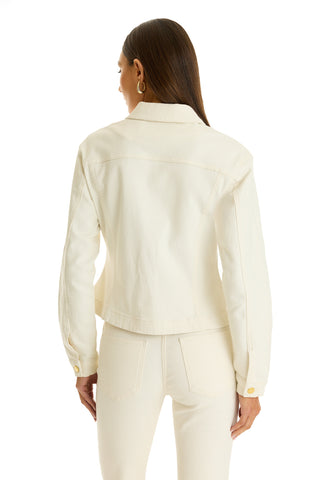 A woman with long brown hair, seen from behind, wears the Bethanie Denim Jacket in ivory with gold buttons and matching high-waisted jeans, standing against a white background.