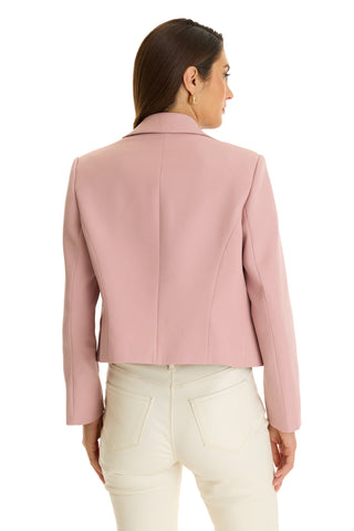 A woman with straight brown hair, seen from the back against a white background, wears a blush Gabrielle Double Breasted Blazer with a tailored waist and high-waisted white pants.