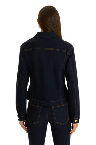 A person with long brown hair, seen from the back, wears the Bethanie Denim Jacket - Indigo with matching jeans, standing against a white background.