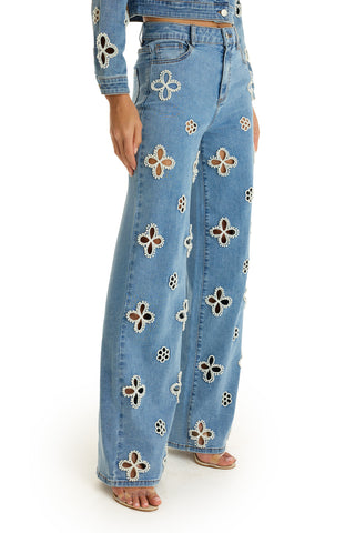 A person wearing the Kaia Pearl High Rise Jean in Medium Blue, showcasing statement denim style.