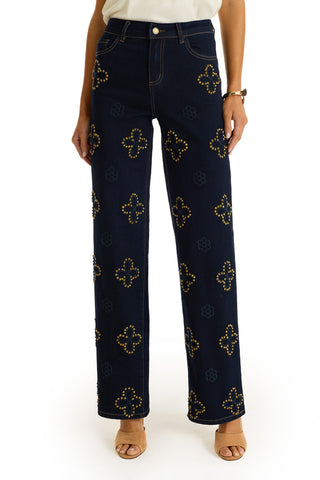 A person wearing the Kaia Studded High Rise Jean in indigo with straight legs and subtle floral stitching.