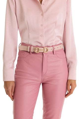 A person wears high-waisted pink pants and a light pink button-up shirt, styled with the Bettie Belt - Blush featuring a gold-toned buckle, shown from shoulder to thigh.