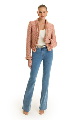 A woman stands against a white background wearing the Florence Tweed Jacket in Rose Multi, paired with a white top, blue high-waisted fringe-hem jeans, a black belt, and nude open-toe heels. Her hair is pulled back and she smiles slightly.