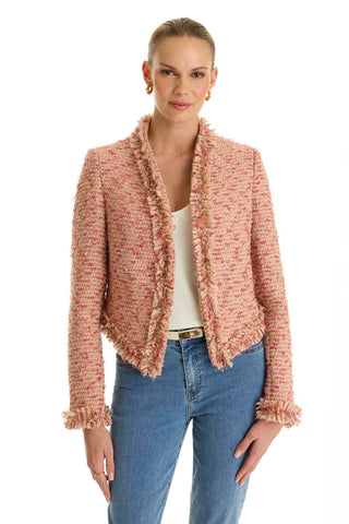 A woman stands facing the camera in the Florence Tweed Jacket - Rose Multi, featuring a textured finish and fringe hem, styled over a white top and blue jeans. She smiles slightly with her hair pulled back against a white background.