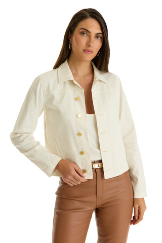 A woman models the Joelle Jean Jacket - Ivory over a white top and high-waisted brown pants, standing with one hand on her jacket against a plain white background.