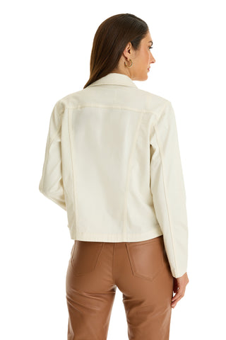 A woman with straight hair and hoop earrings faces away, wearing the Joelle Jean Jacket in Ivory and brown leather pants against a plain white background.