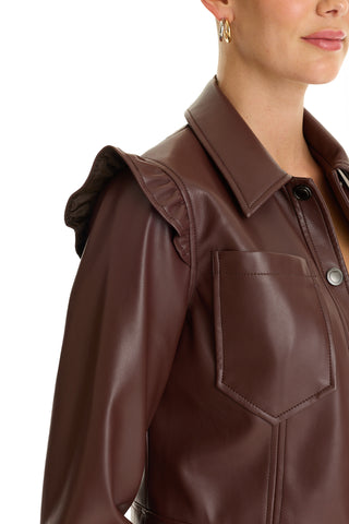 A woman with short hair and gold hoop earrings wears the Chantal Ruffle Sleeve Leather Jacket - Espresso, featuring a large front pocket. Only her upper torso and part of her face are visible—an ideal fall statement piece.