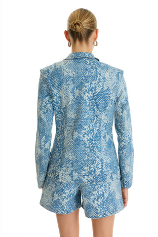 A person with blonde hair in a low bun is seen from behind wearing the Marie Single Breasted Blazer - Crystal Snake with matching shorts against a white background.